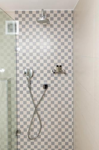 a shower with a hose attached to a tiled wall at Lord Charles Hotel, Somerset West, a Tribute Portfolio Hotel in Somerset West