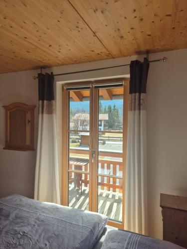 a bedroom with a bed and a sliding glass door at Haus Sunnawind in Wallgau
