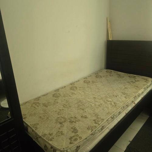 a small bed in a room with a mattress at Bedroom with shared kitchen men only in Sharjah