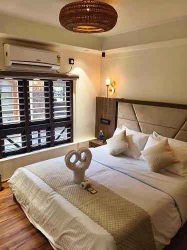a bedroom with a large white bed and a large window at Elagance Premium Houseboats in Alleppey