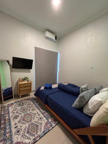a bedroom with a bed and a flat screen tv at Clamitan House Padalarang in Padalarang
