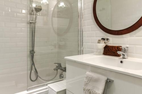 ein weißes Bad mit einer Dusche und einem Waschbecken in der Unterkunft My Casa - France 842 in Nizza