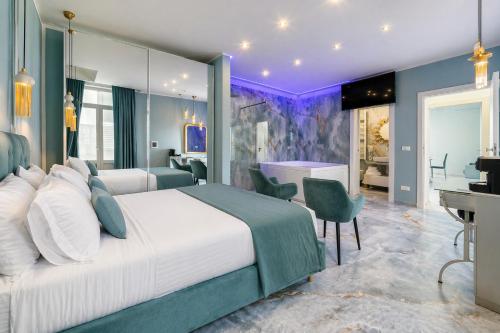a hotel room with a large bed and a desk at Suite Acquamarine by Symphonya Luxury Holiday Rentals in Gallipoli