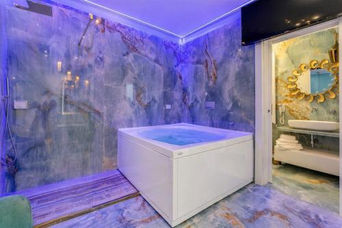 a purple bathroom with a tub and a shower at Suite Acquamarine by Symphonya Luxury Holiday Rentals in Gallipoli