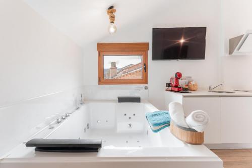 a white bath tub in a bathroom with a tv at ATICO El TRANCO in Villel