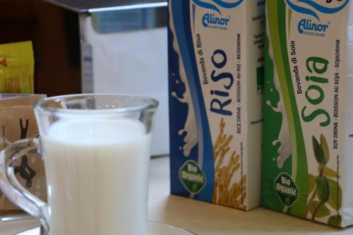 a glass of milk next to a box of milk at Hotel Piacenza in Milan