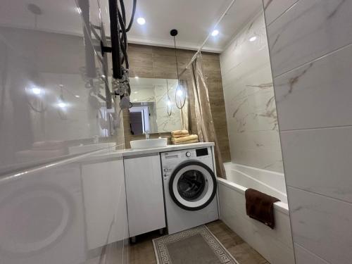 a white bathroom with a washing machine in it at Sweethome Riscani in Chişinău