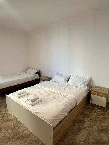 a bedroom with two beds with white sheets at aldo apartments in Shëngjin