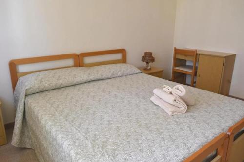 a bedroom with a bed with two towels on it at Appartamenti Onde Blu in Le Castella