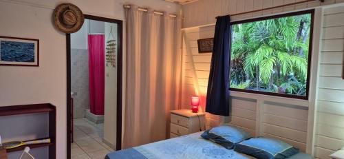 a bedroom with a bed and a large window at LEFOUXIOL in La Trinité