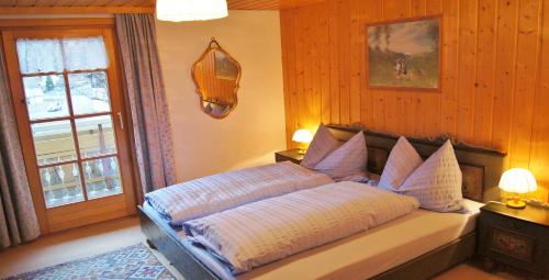a bedroom with a bed with two pillows and a window at Haus Bergfriede in Brand