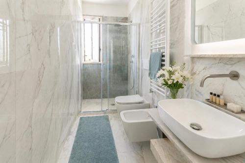 a white bathroom with a sink and a shower at White Loft by Symphonya Luxury Holiday Rentals in Gallipoli
