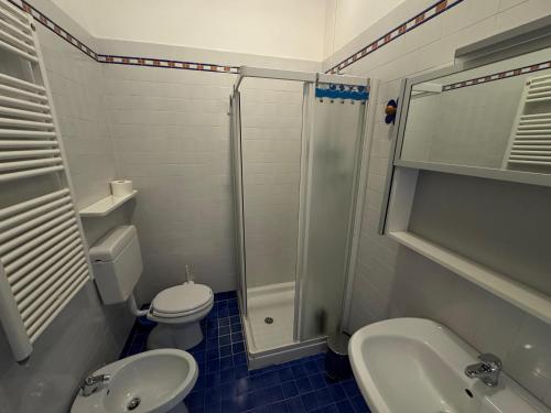 a bathroom with a toilet and a sink and a shower at Villa Ercole in Grado