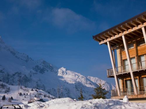 a ski lodge with a snow covered mountain in the background at Grand Hotel Paradiso in Passo del Tonale