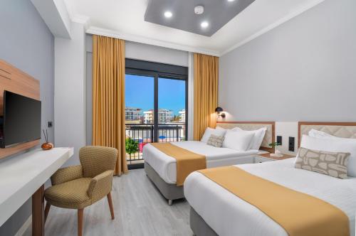 a hotel room with two beds and a tv at Arya inn suit in Serik