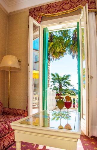 a living room with a glass table and a window at Hotel Terme Roma in Abano Terme