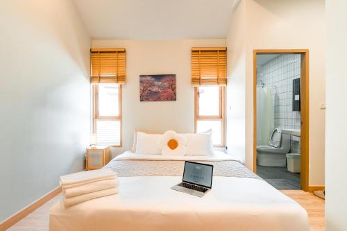 a bedroom with a bed with a laptop on it at Nimman Bed at9 in Chiang Mai