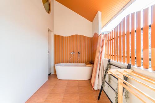 an orange and white bathroom with a tub at Nimman Bed at9 in Chiang Mai
