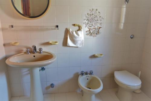 a bathroom with a sink and a toilet and a mirror at Appartamenti Onde Blu in Le Castella