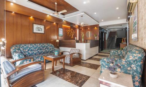 a living room with two couches and a table at Treebo Premium Grand Legacy Elite with Roof Top Cafe in Dehradun