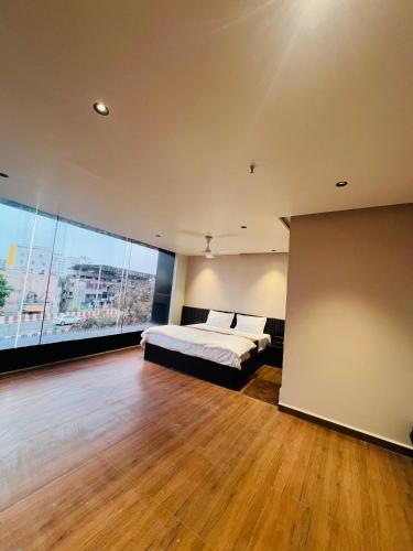 a large bedroom with a bed and a large window at Hotel Presidency - Sosyo Circle in Surat