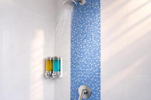 a bathroom with a shower with a shower head at Inn Room Hotel Bajo in Labuan Bajo
