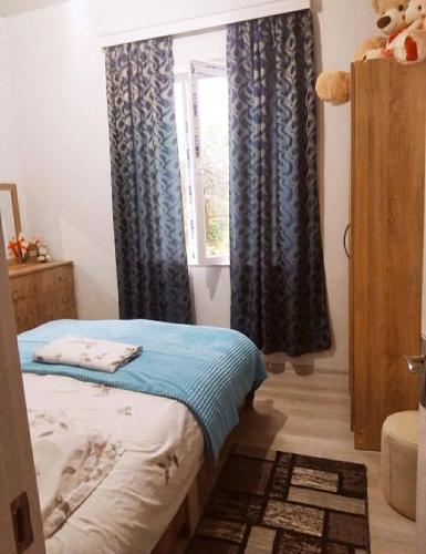a bedroom with a bed and a window at Khatuna Home in Tsqaltubo