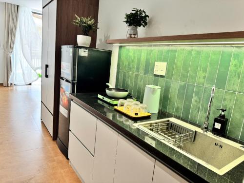 a kitchen with a sink and a refrigerator at An House Son Tra in Danang
