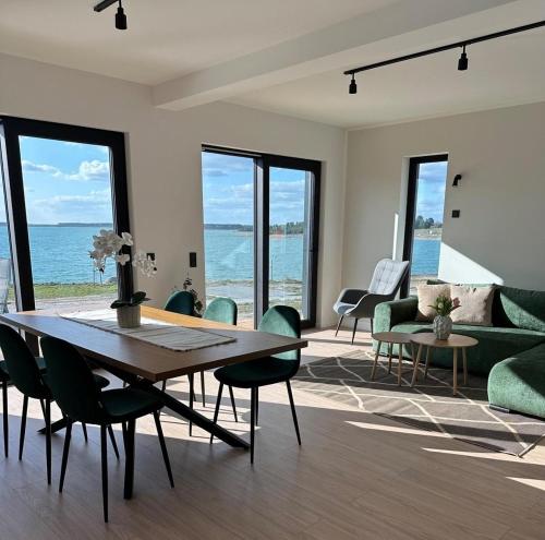 a living room with a table and chairs and the ocean at Ferienhaus Sonnenperle am Partwitzer See in Klein Partwitz