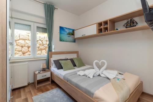a bedroom with a bed with a bow on it at Apartman D&D in Starigrad