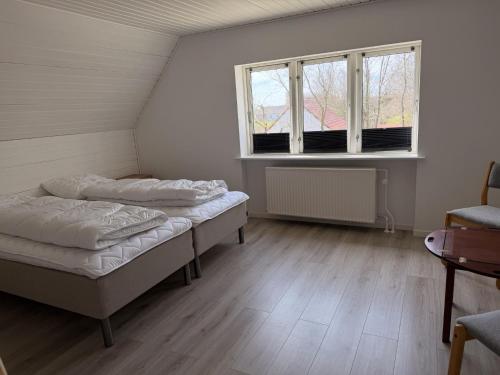 two beds in a room with two windows at Harknakvej 19 BB in Bredebro