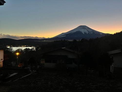 a view of a snow covered mountain at sunset at りす村別荘 in Yamanakako