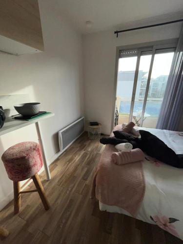 a bedroom with a bed and a desk and a chair at Studio St Marc - plage à 300m in Saint-Nazaire