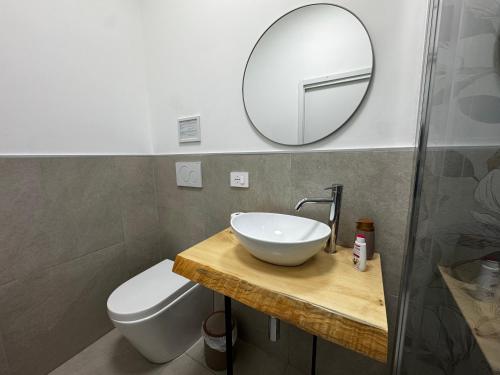 a bathroom with a sink and a toilet and a mirror at Serèsia Rooms Siracusa Centro in Syracuse