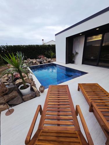 a patio with two benches and a swimming pool at The K Noir Private Pool Luxury Suite in Civé