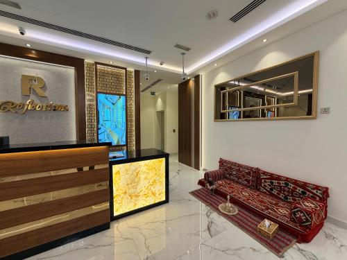 a living room with a couch and a mirror at Reflections Hotel in Dubai