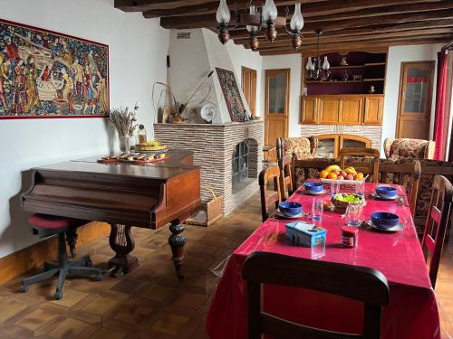 a dining room with a table and a piano at Les Billardières - Suite familiale de 2 chambres entre Blois et Chambord, proche Loire à Vélo in Cour-sur-Loire