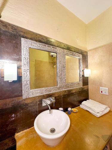 a bathroom with a sink and a mirror at Wild Meadows by Levitate - Exclusive Dual Bedroom Chalet Open Sky View & Fully Equipped Kitchen in Rāmgarh