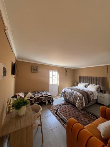 a bedroom with two beds and a living room at Zambata Self Catering in Gqeberha