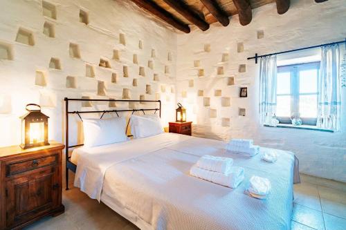 a bedroom with a large white bed with towels on it at The Vintage Dovecote in Mesariá