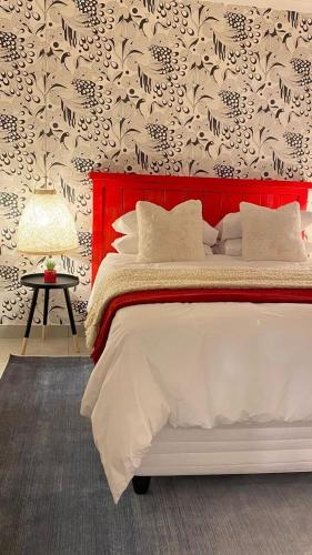a bedroom with a large bed with a red headboard at Townside Estate UNIT8 in Ladysmith