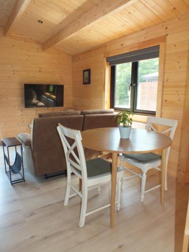 a living room with a table and a couch at KILLARNEYCABINSie Stunning & Spacious Scandanavian Timber Lodges in Killarney