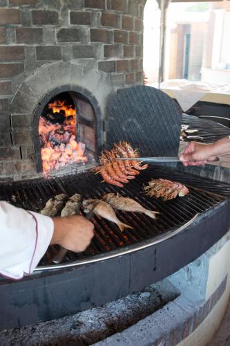 a person is cooking food on a grill at Hotel Hermitage in Portoferraio