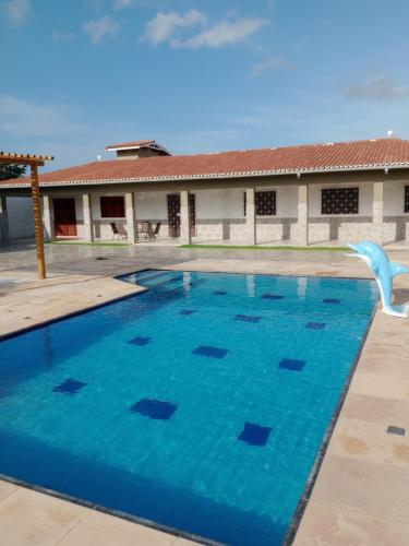 a swimming pool with a dolphin in the water at Casa Carlotta in Paracuru