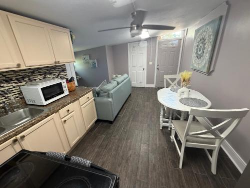 a kitchen and dining room with a table and a microwave at Backyard Cottage in Naples