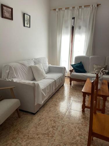 a living room with a white couch and a table at Espera Apartamentos in Espera