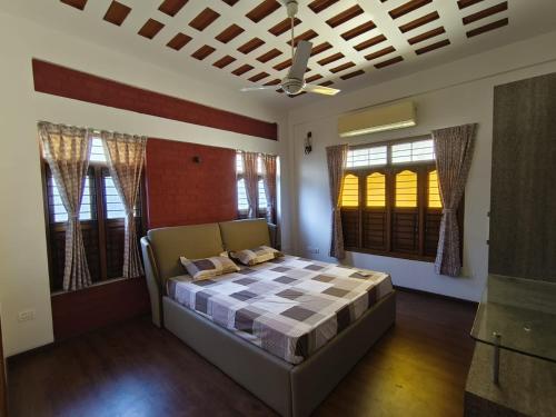 a bedroom with a bed in a room with windows at SIENNA Ecr in Chennai