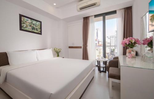 a white hotel room with a bed and a window at Sophia Central Nha Trang Hotel by HT in Nha Trang