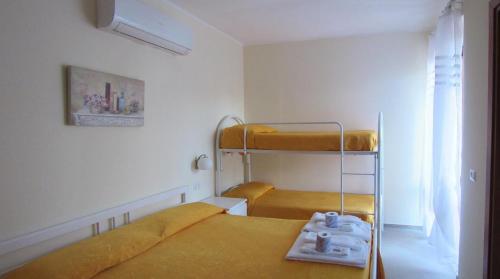 a small room with two bunk beds and a window at Hotel Santa Rosalia in Marina di Camerota