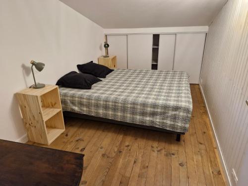 a bedroom with a bed and a lamp on a wooden floor at Maison en pierre Ardèche du sud in Valgorge